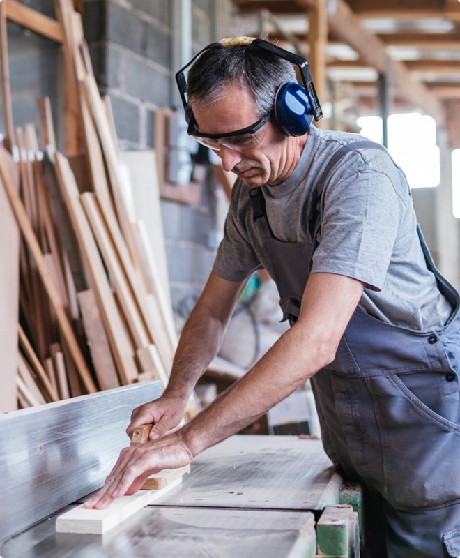 A carpenter wearing ear and hearing protection as he works on a wood project in his Indiana home.